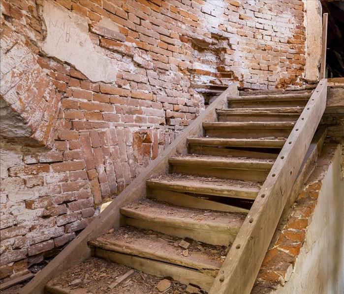 A set of stairs in a building that has long been abandoned.
