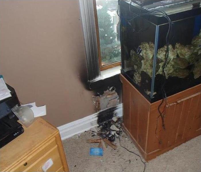 charred baseboard and window trim from small electrical fire behind the fish tank