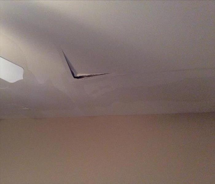 water stains and broken sheetrock on a ceiling from water damage