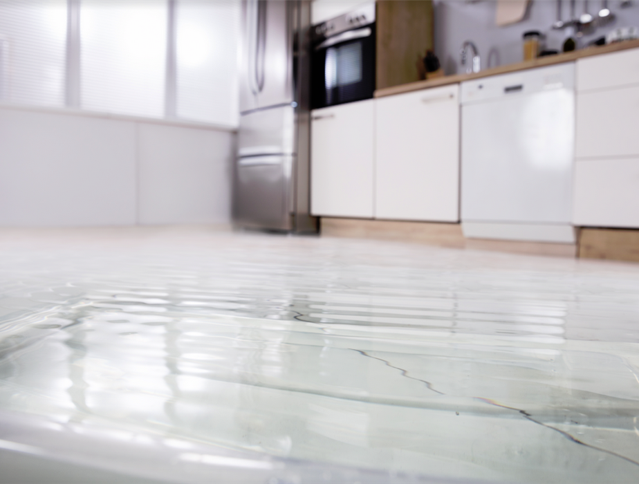 flooded kitchen flooring in front of washing machine
